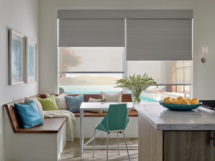 A kitchen with blue-green accents and a bowl of oranges.